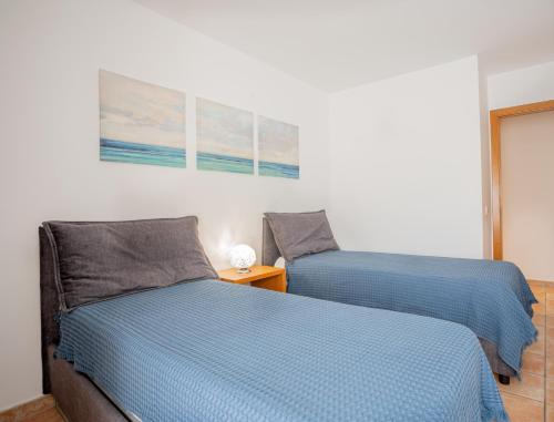 Duas camas sentadas uma ao lado da outra num quarto em Apartamentos Turisticos CAN CUNILL em Es Pujols