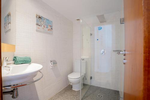 uma casa de banho com um WC, um lavatório e um chuveiro em Apartamentos Turisticos CAN CUNILL em Es Pujols