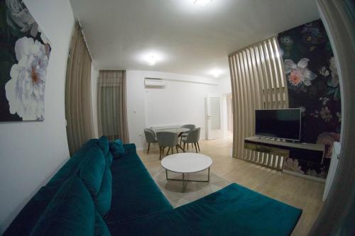 a living room with a blue couch and a table at Apartman David in Trebinje