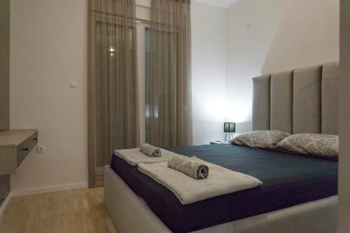 a bedroom with a large bed with a blue blanket at Apartman David in Trebinje