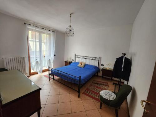1 dormitorio con 1 cama azul y 1 silla en Appartamento Vale, en Villanuova sul clisi