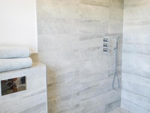 uma casa de banho com um chuveiro e uma porta de vidro em Valhallah Cottage Retreat em Broomhill