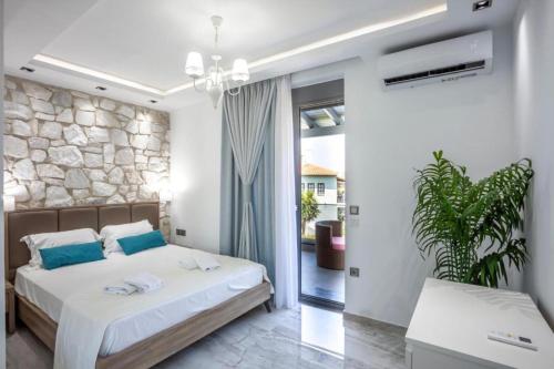 Un dormitorio con una cama y una pared de piedra. en Villa Marietta The First, en Chaniotis