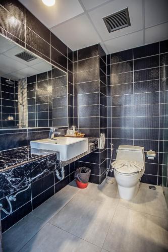 a bathroom with a toilet and a sink at Embryo Hotel  in Pattaya Central