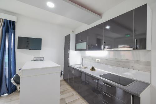 a kitchen with black and white cabinets and a sink at Boutique Apartments Ad Astra in Bibinje