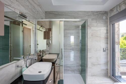a bathroom with a sink and a glass shower at Villa Marietta The First in Hanioti