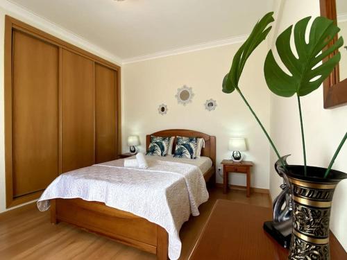 een slaapkamer met een bed en een potplant bij Little Rose Vila Rosa in Portimão
