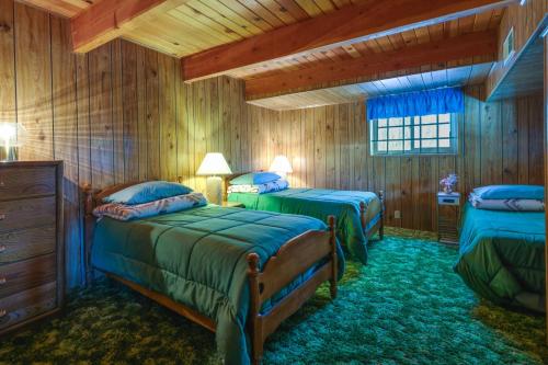 two beds in a room with wooden walls at California Retreat Near Yosemite National Park! in Twain Harte