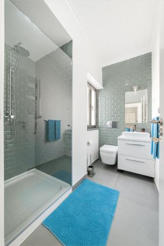 a bathroom with a shower and a blue rug at Beachouse - Surf, Bed & Breakfast in Ericeira