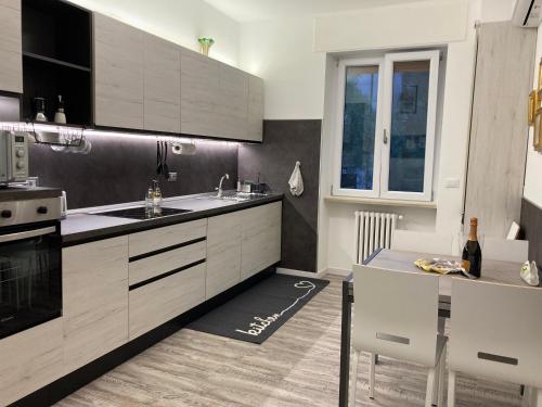 - une cuisine avec des placards blancs, un évier et une table dans l'établissement Garda Art&Lake, à Peschiera del Garda
