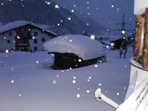 a car covered in snow on a city street at Haus Mattle in Pettneu am Arlberg