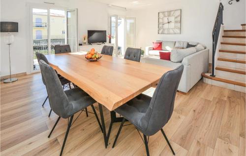 une salle à manger avec une table et des chaises en bois dans l'établissement Cozy Home In Aigues-Mortes With Wifi, à Aigues-Mortes