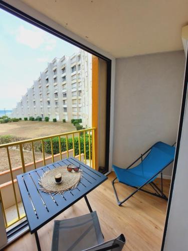 a balcony with a table and chairs and a view of a building at Magnifique studio cosy vu mer avec Wifi in Le Barcarès