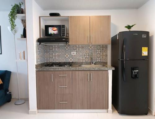uma cozinha com um frigorífico preto e um micro-ondas em Casa moderna y acogedora. em Salento