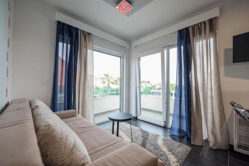 a living room with a couch and a large window at Boutique Apartments Ad Astra in Bibinje