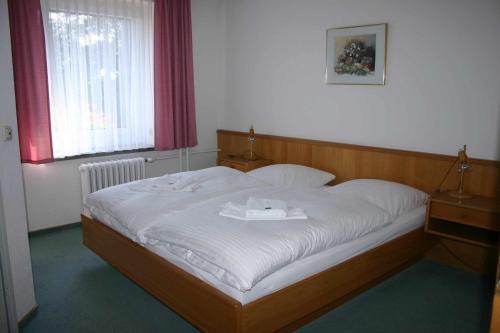 a bedroom with a bed with white sheets and a window at Hotel Zum Alten Brauhaus in Kurort Oberwiesenthal