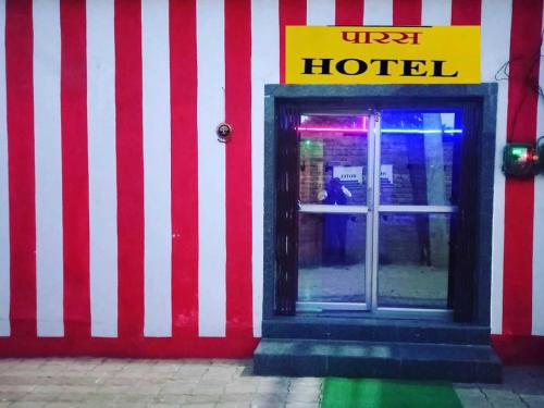 a red and white striped facade of a hotel at OYO Paras Hotel in Jamūi