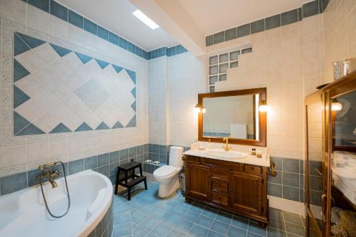 a bathroom with a tub and a sink and a toilet at Rio Beach Residence in Patra