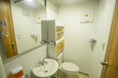 Baño pequeño con aseo y lavamanos en INDUSTRIAL LODGE, EN CALI, IMBANACO, Hospedaje Mi Fortaleza Cali en Cali
