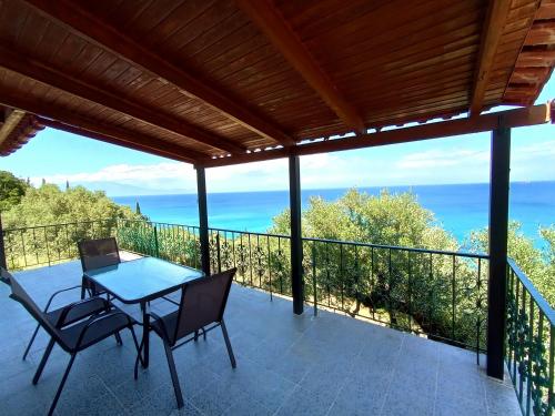 a patio with a table and chairs on a balcony at Xigia hideaway - panoramic sea view house in Zakynthos Town