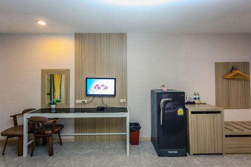 a room with a desk and a refrigerator in a room at Embryo Hotel  in Pattaya Central