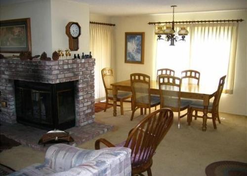 ein Wohnzimmer mit einem Kamin, einem Tisch und Stühlen in der Unterkunft Rr-interlaken 25 in June Lake
