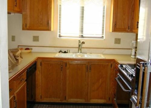 eine Küche mit Holzschränken, einem Waschbecken und einem Fenster in der Unterkunft Rr-interlaken 25 in June Lake