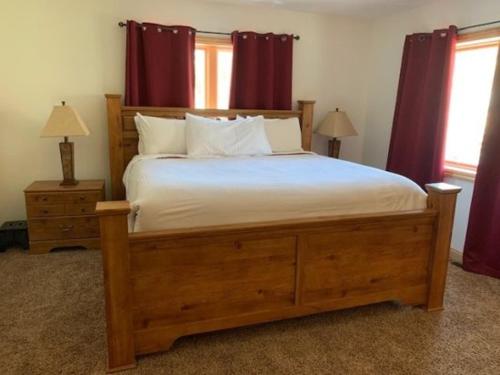 a bedroom with a large wooden bed with red curtains at Rr-johnson Suite 2 in June Lake