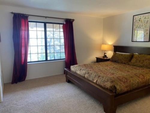a bedroom with a bed and a window with red curtains at Rr-interlaken 13 in June Lake