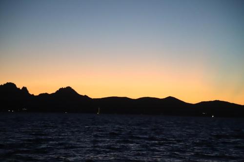 a sunset with mountains in the background at Villetta Il Faro sul Mare in Àrbatax