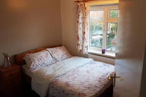 a small bedroom with a bed with a window at Two bedroom maisonette close toWarwick Uni in Canley