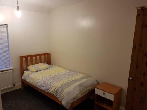 a small bedroom with a bed and a night stand at Two bedroom maisonette close toWarwick Uni in Canley