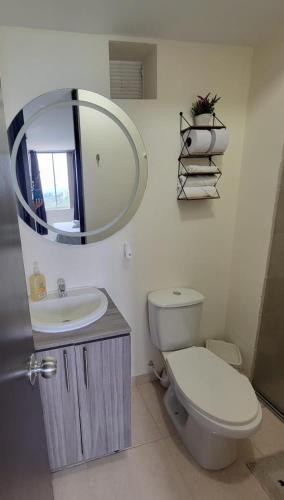 a bathroom with a toilet and a sink and a mirror at APARTAESTUDIO en el Norte de Armenia, en la via a Salento y Filandia Con parqueadero de carro in Armenia