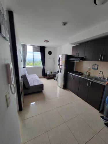 a kitchen with a couch in the middle of a room at APARTAESTUDIO en el Norte de Armenia, en la via a Salento y Filandia Con parqueadero de carro in Armenia