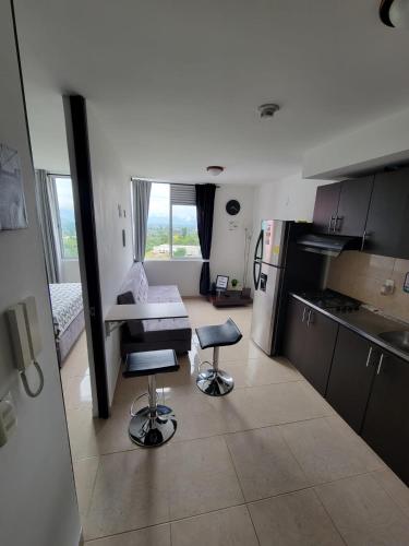 a kitchen with two stools in the middle of a room at APARTAESTUDIO en el Norte de Armenia, en la via a Salento y Filandia Con parqueadero de carro in Armenia