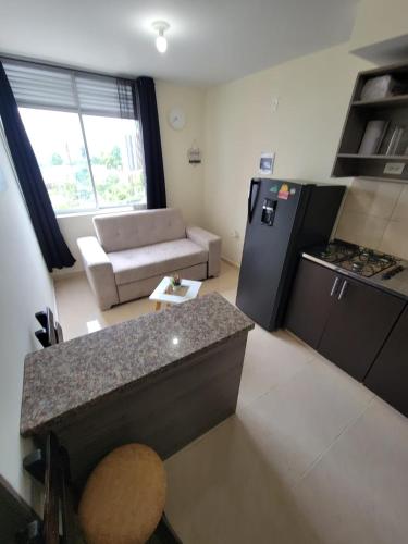 a kitchen and living room with a couch and a counter at APARTAESTUDIO en el Norte de Armenia, en la via a Salento y Filandia Con parqueadero de carro in Armenia