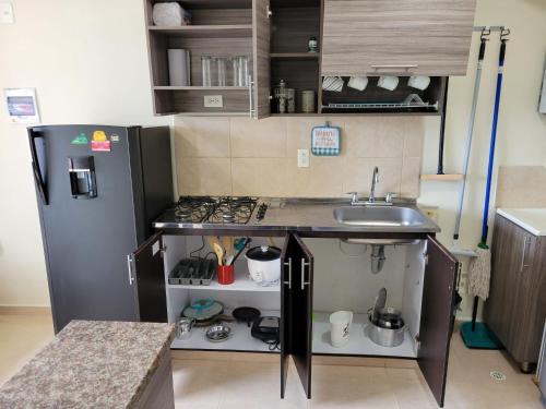 a small kitchen with a sink and a refrigerator at APARTAESTUDIO en el Norte de Armenia, en la via a Salento y Filandia Con parqueadero de carro in Armenia