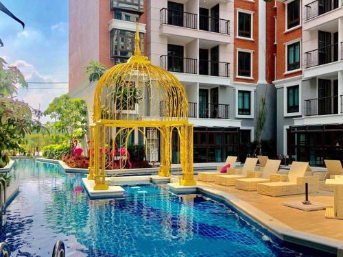 a gold gazebo in the middle of a swimming pool at Espana Condo Resort Pattaya BY MAM in Jomtien Beach