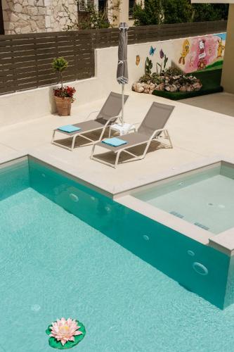 two lounge chairs and a swimming pool in a backyard at Avidianos' -Family Perfect- Residence in Astérion