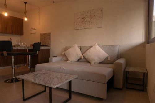 a living room with a couch and a table at Seuia Departamentos con alberca a pasos del lago in Ajijic