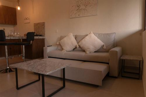 a living room with a couch and a table at Seuia Departamentos con alberca a pasos del lago in Ajijic