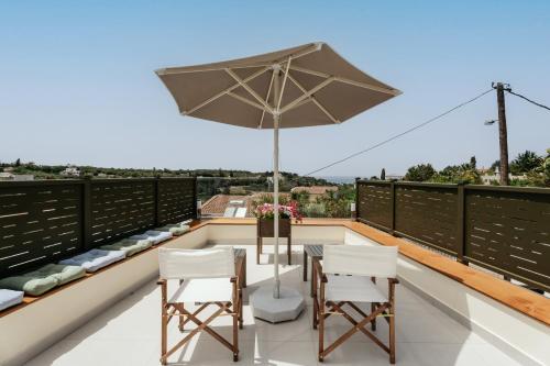 a patio with an umbrella and chairs on a roof at Avidianos' -Family Perfect- Residence in Astérion