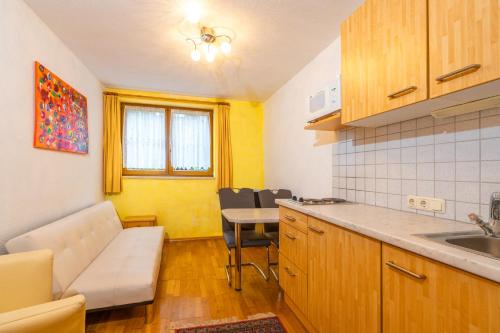a kitchen with a couch and a table in a room at Appart Taverne in Mayrhofen