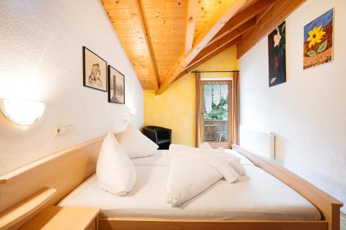 a bedroom with a large bed with white pillows at Appart Taverne in Mayrhofen