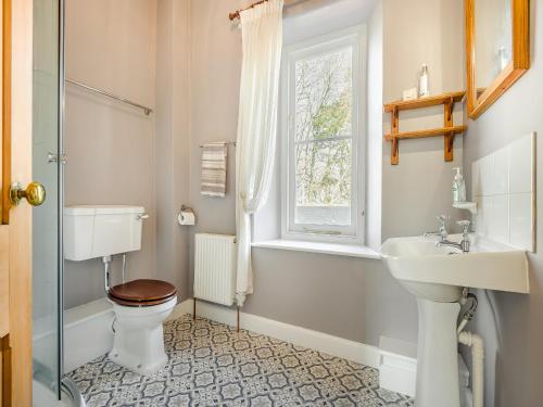 a bathroom with a toilet and a sink and a window at Barleycombe in Loxton