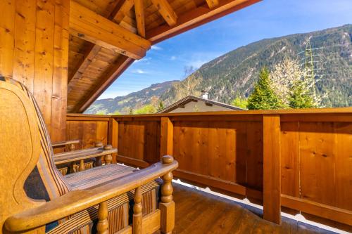 a porch of a cabin with a bench and mountains at Appart Taverne in Mayrhofen