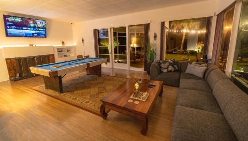 a living room with a couch and a pool table at Hilltop Legacy Vacation Rental in Hilo