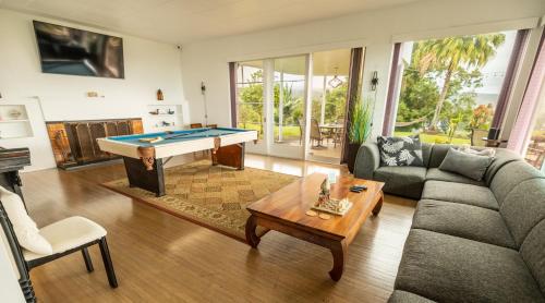 a living room with a couch and a pool table at Hilltop Legacy Vacation Rental in Hilo