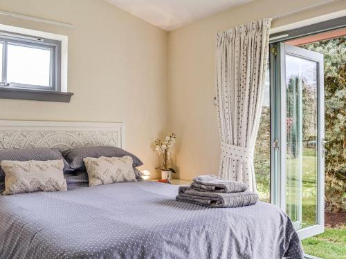 a bedroom with a bed and a large window at Viola Cottage in Blairgowrie