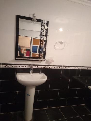 a bathroom with a sink and a mirror at Residence al Rahma nr 01 in Monte ʼArrouit